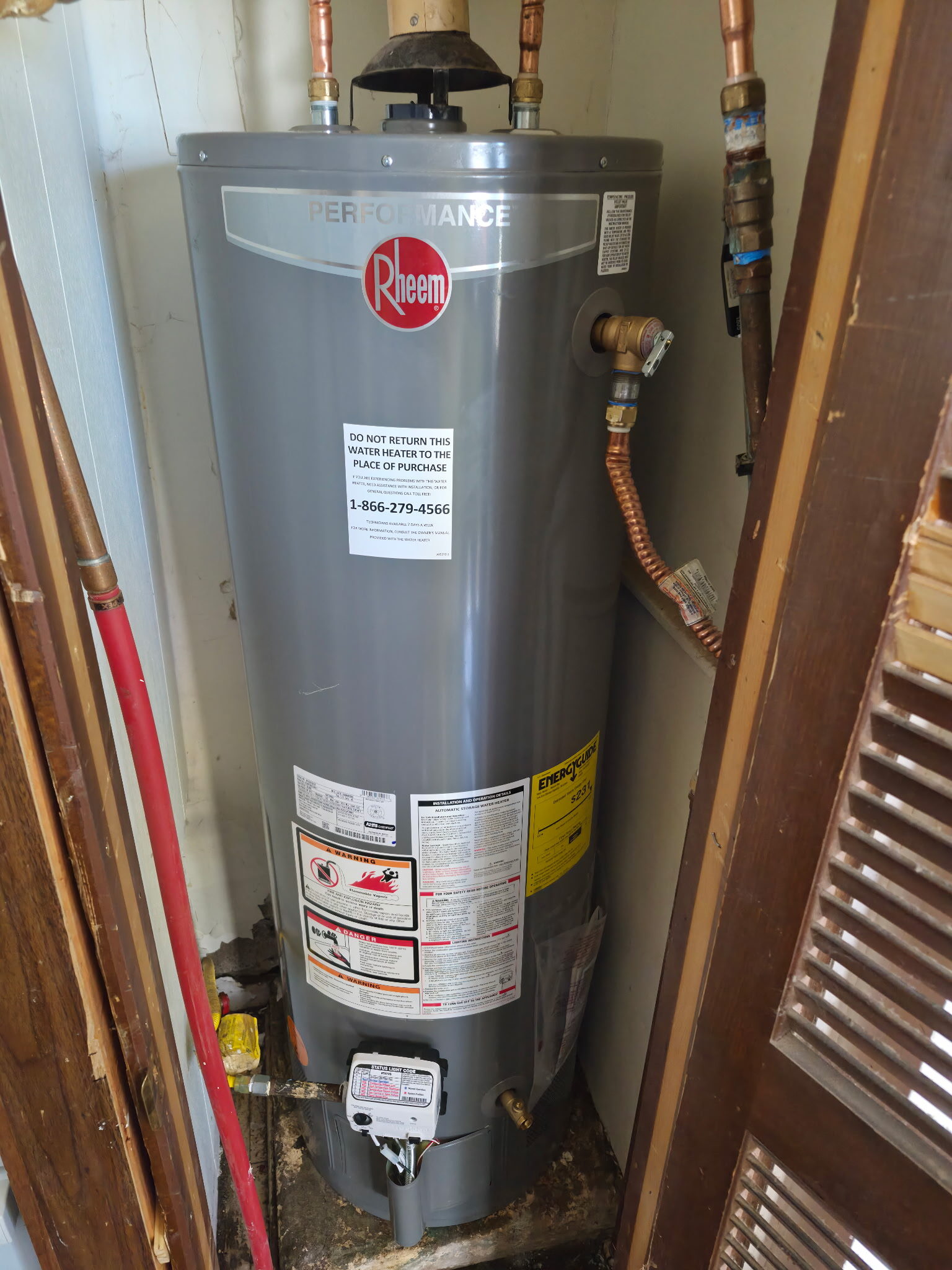New Rheem gas water heater installed in utility closet